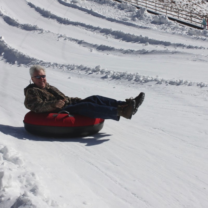 a man riding a snowboard down a snow covered slope