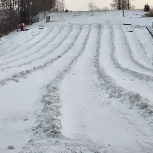 a group of people riding skis across snow covered ground